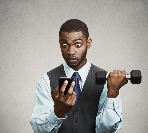 Closeup portrait shocked, surprised business man reading bad news on smart phone holding mobile, lifting weight, dumbbell isolated black background. Human face expression, emotion, corporate executive